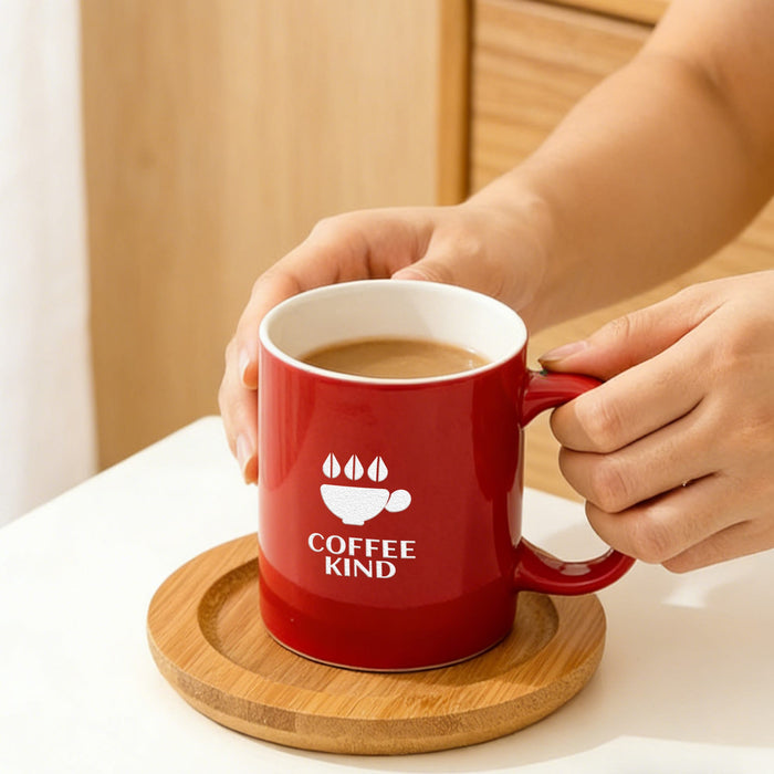 Laser Engraving Ceramic Mug - A red ceramic mug with a white interior, featuring a logo and sitting on a wooden coaster.
