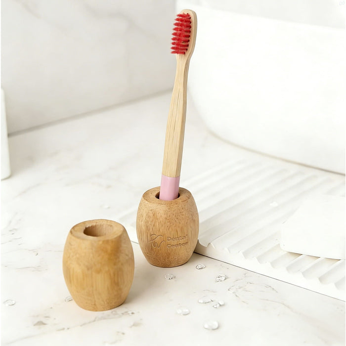 Bamboo Toothbrush Stand - A bamboo toothbrush stand in natural wood tones, featuring two holders with a toothbrush placed in one.