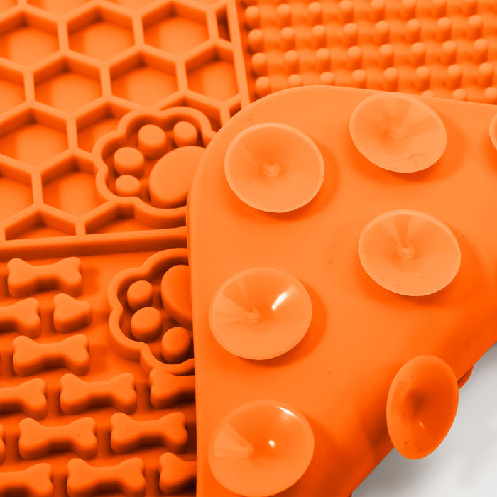 4-Section Dog Enrichment Lick Mat - An orange silicone lick mat divided into four sections with various textures, including honeycomb and paw prints.