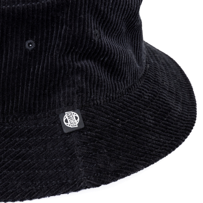 Atlanta Cord Bucket Hat - A black corduroy bucket hat featuring a logo on the side. The texture is clearly visible.