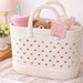 Mini EVA Holes Bag Clip - A basket with a white design featuring holes, holding a pink drink bottle, a teddy bear, and a soft toy.