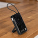 Eclipse Magnetic Power Bank 10000mAh - A black power bank with a magnetic feature and a stand, set on a wooden surface. It includes a textured strap for easy handling.