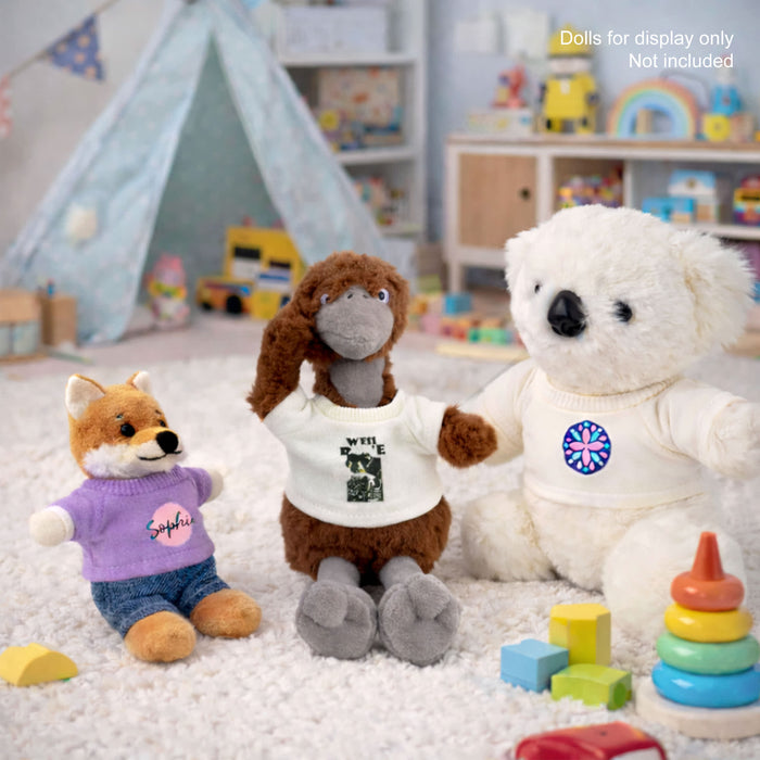 Plush Doll Basic T-Shirt - A plush doll wearing a white T-shirt, alongside a koala and a fox in colourful outfits, with toys in the background.