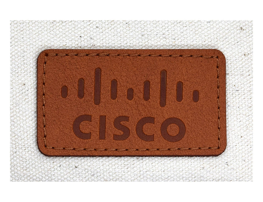 Calico Travel Set - A brown leather patch featuring a logo, with tan stitching on a light fabric background.