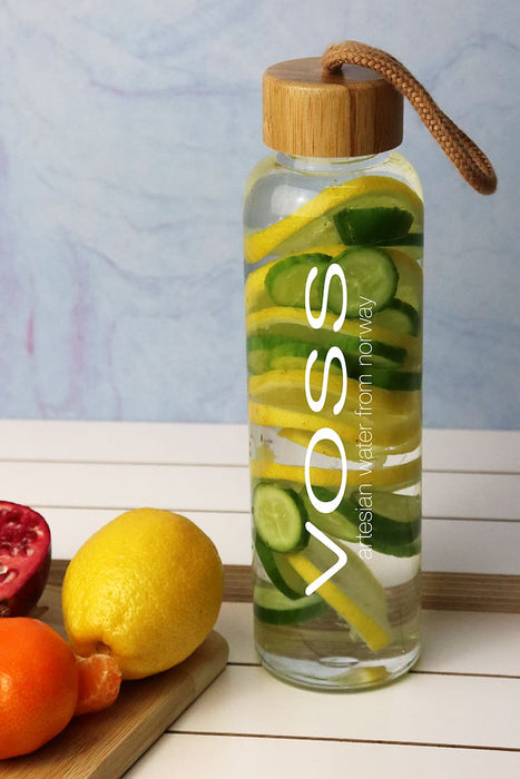 Vidro 550ml Bottle - A drink bottle with a clear body, bamboo lid, and filled with sliced cucumber, lemon, and pomegranate. It features a logo.