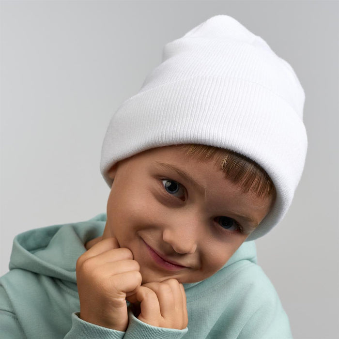 Kid Wind-S Beanie - Recycled Polyester - A white beanie made from recycled polyester, worn by a smiling child in a green hoodie.
