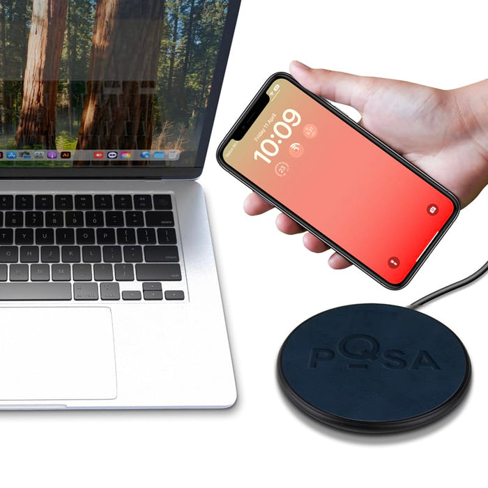 Casper Pro 15 Watt Eco Wireless Charger - A wireless charger with a circular design in black, positioned next to a laptop and a smartphone.