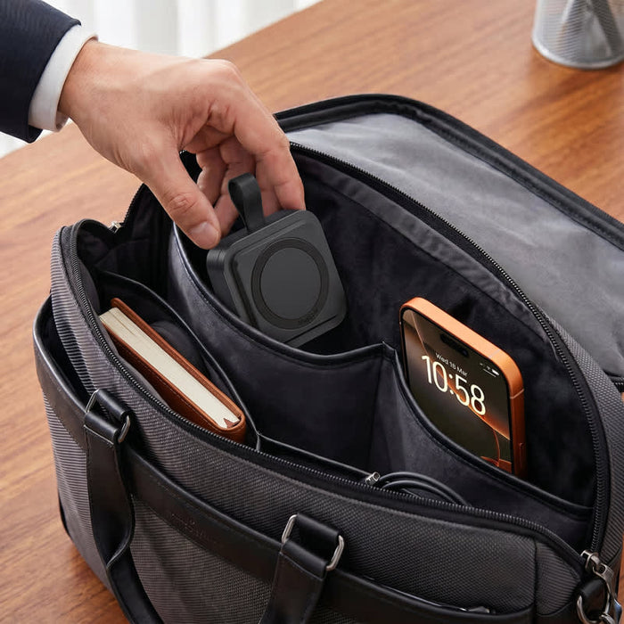 Everest 3-in-1 15W Magnetic Wireless Charging Station - A black magnetic wireless charging station is placed inside a dark bag alongside a phone and a notebook.