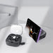 Catania Retractable 60W Fast Charging and Data Cable Set - A black retractable cable set in a case, with a smartphone propped up, displaying a music player interface.
