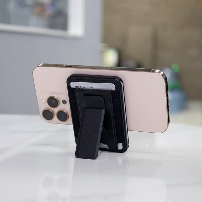 Wally Stand - A phone with a black wallet case and kickstand, resting on a marble surface, featuring visible credit cards.