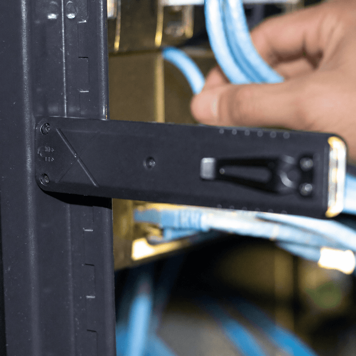 Rechargeable Work Light - A black tool with a handle and measurement markings, positioned near blue cables in a rack.