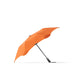 BLUNT Metro Umbrella - An orange BLUNT Metro Umbrella with a sleek design and a black handle, featuring a logo on the canopy.