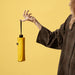 BLUNT Neo Umbrella - A yellow compact umbrella held by a person, with a plain background and a visible logo on the umbrella.