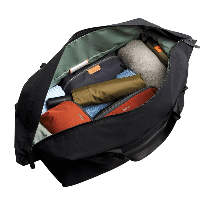 Bellroy Classic Duffel 45L - A black duffel bag open to reveal neatly packed items, including clothing and accessories in various colours.