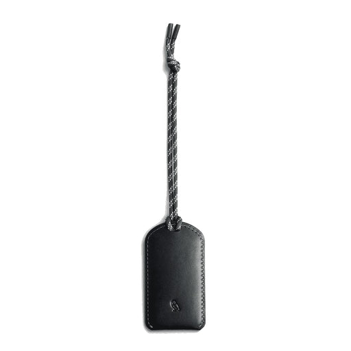 Bellroy Luggage Tag - A black luggage tag made of leather, featuring a braided attachment. It has a logo on its surface.