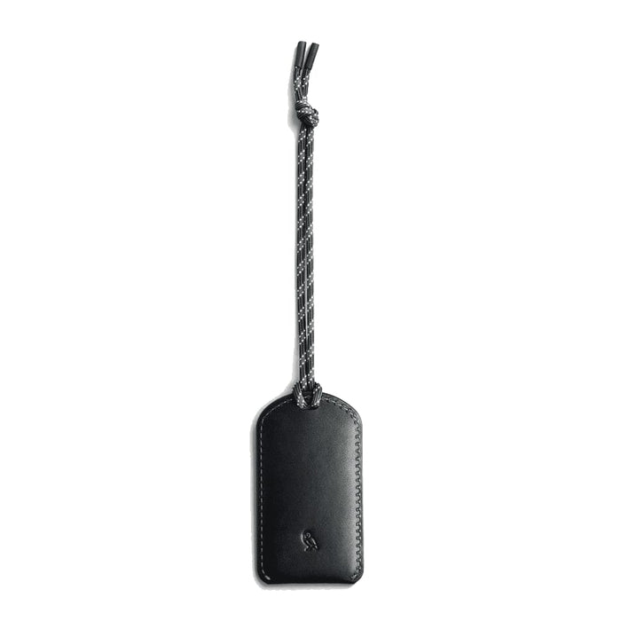 Bellroy Luggage Tag - A black luggage tag made of leather, featuring a braided attachment. It has a logo on its surface.