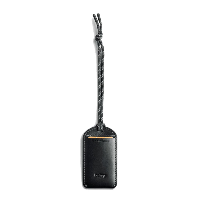 Bellroy Luggage Tag - A black leather luggage tag features a braided strap and a logo. The design is sleek and minimalist.