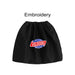 Waterproof Boot Covers - A black boot cover with a round logo featuring red and blue elements, and an embroidered text design.