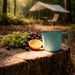 350ML Camping Stainless Steel Insulated Mug - A stainless steel insulated mug in teal sits beside a mix of grapes and an orange on a wooden stump in a forest setting.