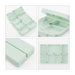 Folding 7 Compartment Pills Box - A light green folding pill box with seven compartments, featuring a small button for secure closure.