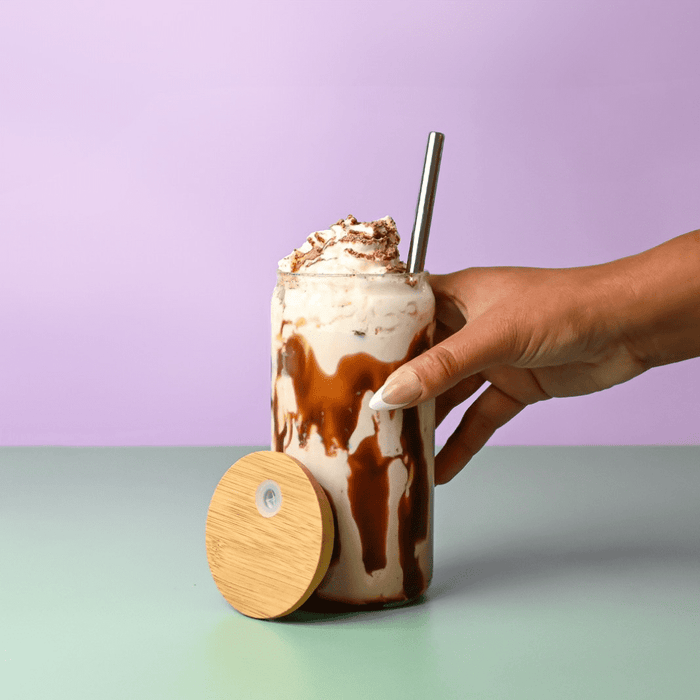 Carnaby 500ml Tumbler - A drink bottle with a bamboo lid, featuring a creamy beverage topped with whipped cream, held in a hand.