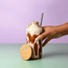 Carnaby 500ml Tumbler - A drink bottle with a bamboo lid, featuring a creamy beverage topped with whipped cream, held in a hand.