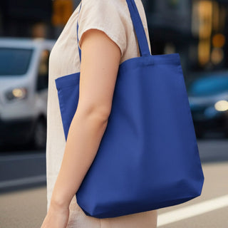 450gsm Hawaiian Canvas Tote Bag - A blue reusable grocery tote bag with a single strap, held by a person on a city street.