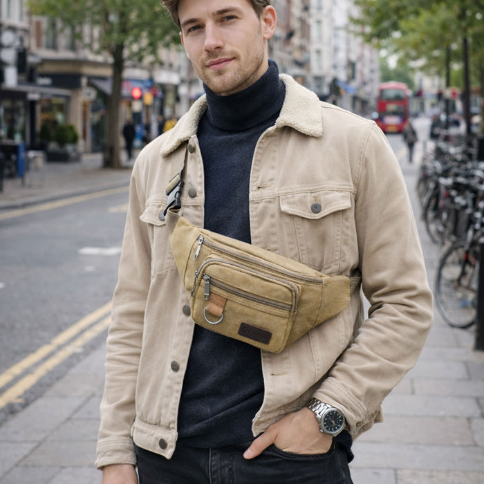 Canvas Waist Bag - A man wearing a tan canvas waist bag over a black turtleneck, standing on a city street.