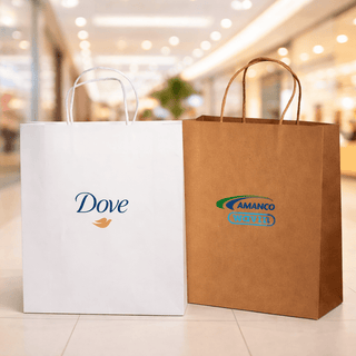 Paper Shopping Bag - Two paper shopping bags are displayed, one white with a logo and the other brown with a logo, set in a retail environment.