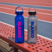 Clearview RPET 630ml Drink Bottle - A drink bottle set featuring a blue and a clear design, both with a logo and cap, resting on a bench.