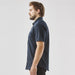 Men's Sonora Short Sleeve Knit Shirt - A dark navy short sleeve button-up shirt displayed on a model from the side, featuring a pocket and a logo.
