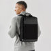 Cupertino Commuter Pack - A man wearing a grey and black laptop bag on his back, featuring a logo and a minimalist design.