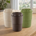 Ecco Kuppa – EcoBlend - A drink bottle in three colours: cream, dark brown, and green, with a ribbed design and a lid, featuring a logo.