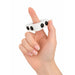 Decompression Finger Spinner - A white finger spinner held between fingers, featuring three black buttons on its surface.