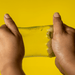 Jelly Cube Sensory Toy - A pair of hands stretching a translucent yellow jelly cube sensory toy against a bright yellow background.