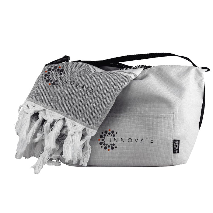 Towel & Cooler Bundle Pack - A cooler bag in grey with a black strap, alongside a matching grey towel featuring tassels and a logo.