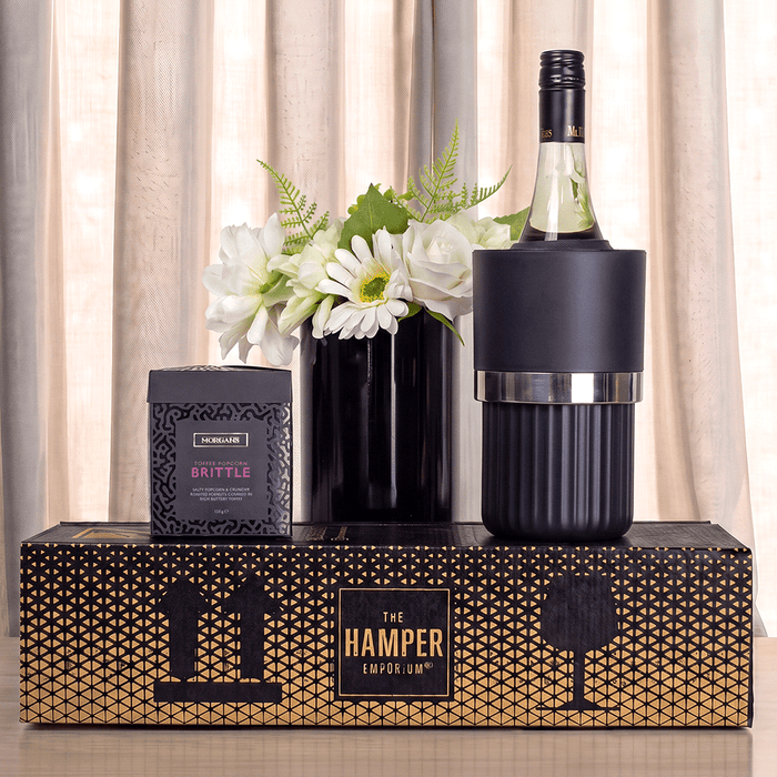 The Entertainer Set - A drink bottle in a black cooler, alongside a box of brittle and a black vase with white flowers.