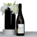 The Entertainer Set - A sparkling wine bottle with a black label next to a black vase filled with white flowers.