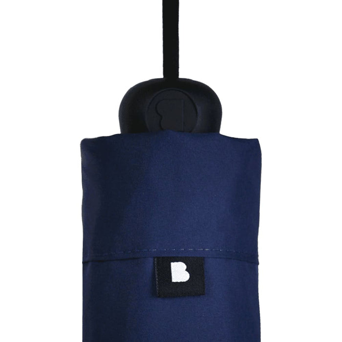 The Blunt Umbrella All Weather Set - A navy blue umbrella set with a black handle, featuring a branding label on the cover.