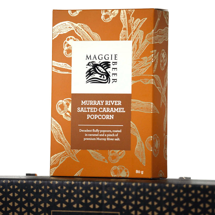 The Blunt Umbrella All Weather Set - A box of Maggie Beer Murray River Salted Caramel Popcorn in a decorative orange packaging, featuring a logo.