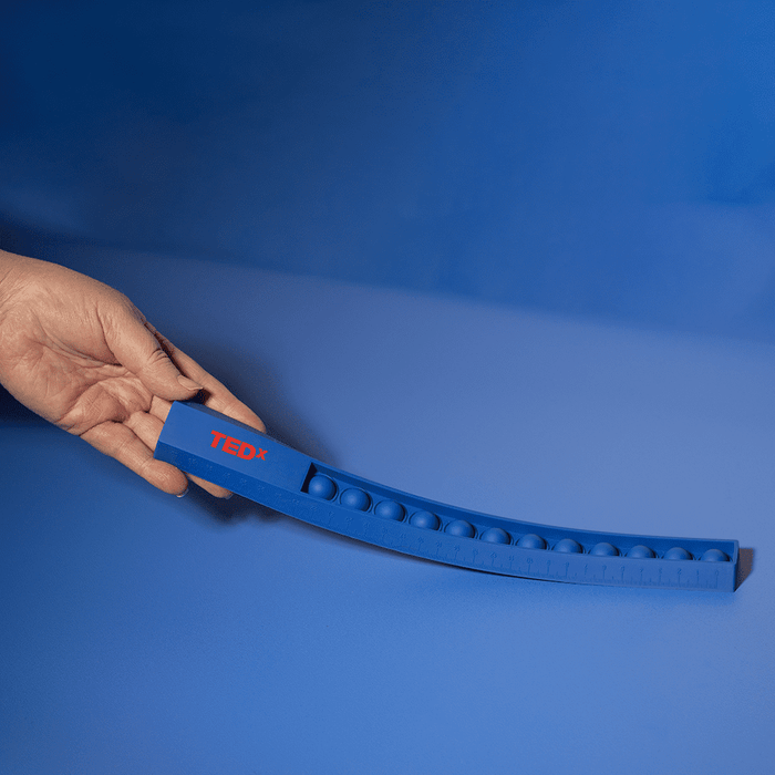 30cm Popper Ruler - A blue 30cm popper ruler with a hand holding it, featuring a textured popping surface and a logo.