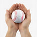 High Bounce Base Ball - A white baseball with red stitching held between two hands. The hands are open, supporting the ball gently.