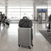 High Sierra Travel Duffel - A grey High Sierra travel duffel rests on top of a silver suitcase in an airport terminal. It features a logo.