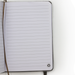The Barker Eco Notebook - B6 - An open notebook with lined pages and a logo in the bottom corner. The cover is a neutral colour.