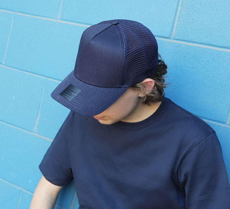 Cotton/Mesh - A navy blue cap with a mesh back, resting on the head of a person wearing a matching navy shirt.