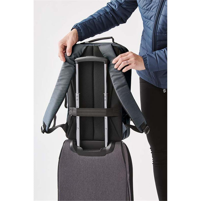 Hedmark Commuter Backpack - A grey Hedmark Commuter Backpack with padded straps being attached to a suitcase for easy transport.