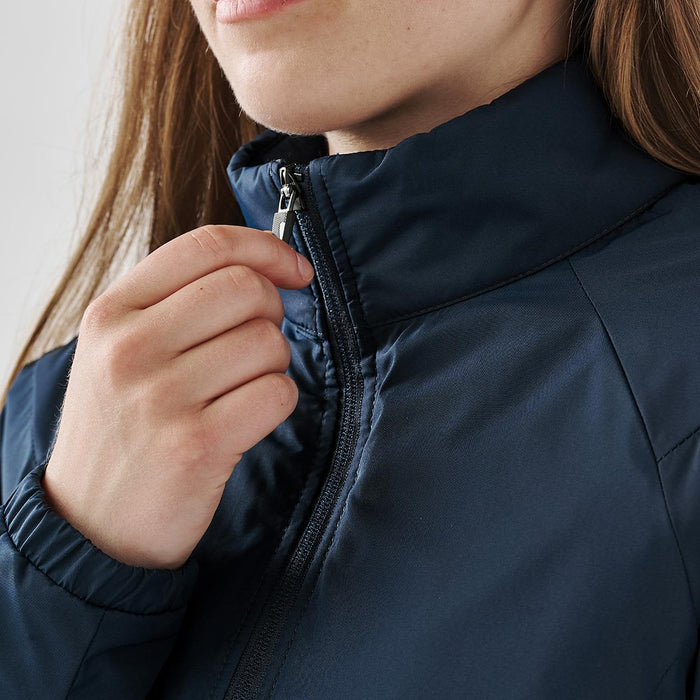 Women's Pacifica Thermal Jacket - A close-up of a woman's hand adjusting the zipper of a navy thermal jacket with a high collar.