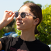 Summer Polarised Sunglasses - A pair of clear and dark grey polarised sunglasses worn by a person with a ponytail, outdoors.