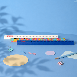 30cm Popper Ruler - A 30cm popper ruler in blue with a colourful design, surrounded by stationery items like paperclips and circular paper.