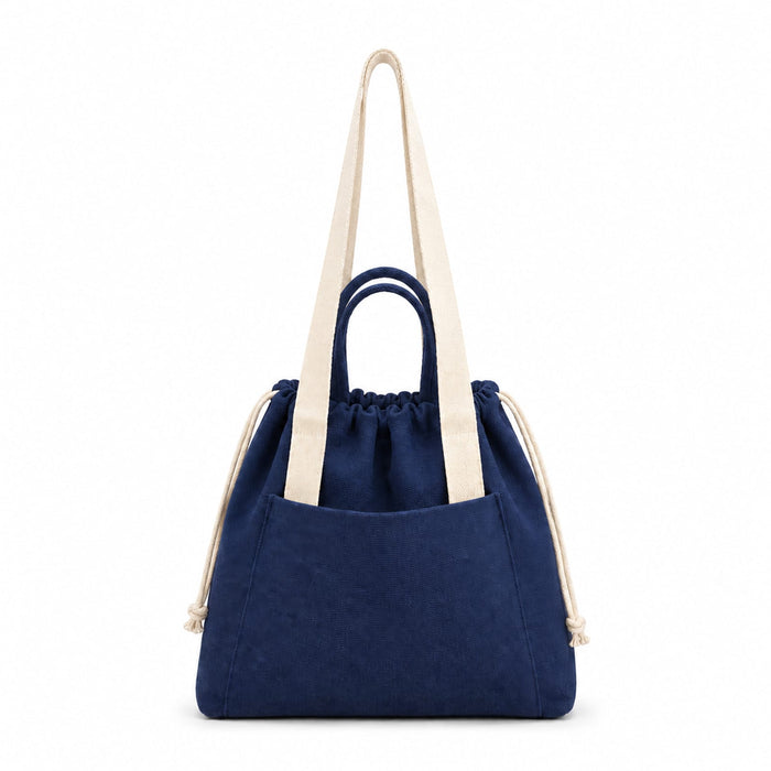 Darby Tote Bag - A navy tote bag with cream handles and a drawstring closure, featuring a front pocket and branding.